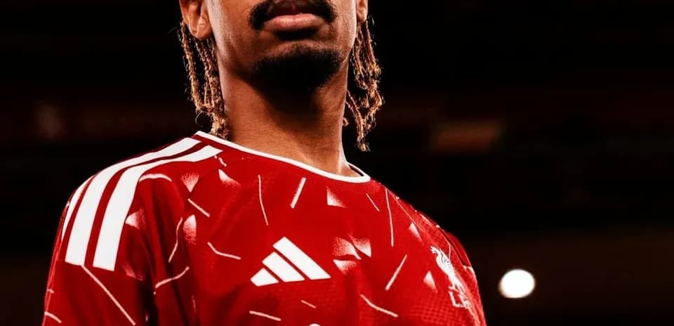 Futbolchi qizil forma kiyib turgan