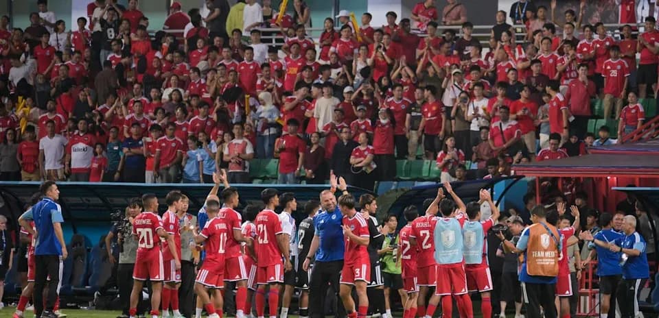 Football team celebrating with fans after match