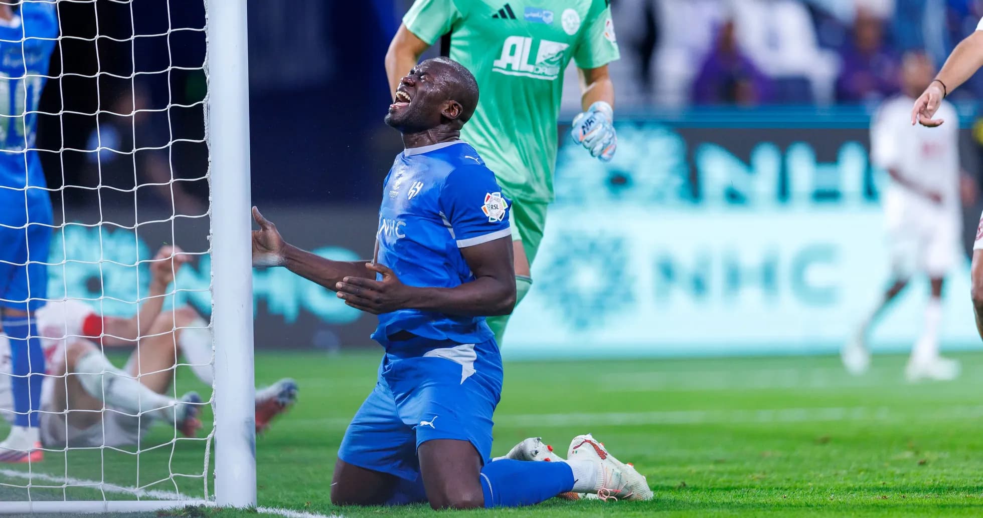 Player kneeling near goalpost after missing chance