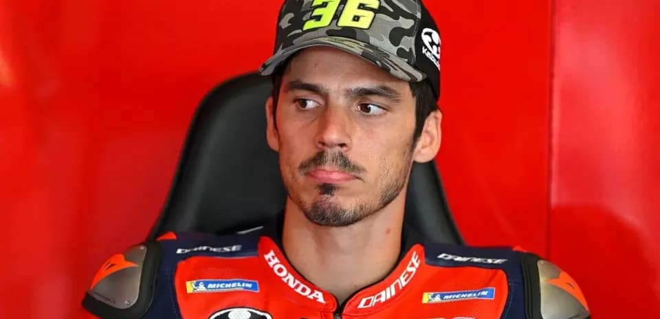 MotoGP rider in team gear sitting in garage
