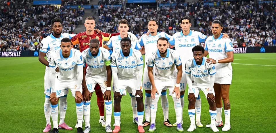 Olympique de Marseille team posing on the pitch