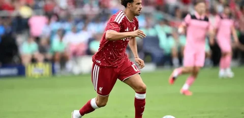 Futbolchi to'pni ushlab, maydon bo'ylab harakatda