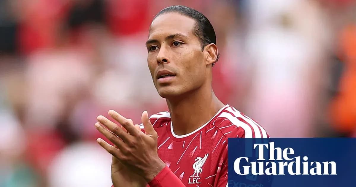 Futbolchi LFC formasida maydonda qo'llarini qimirlatmoqda