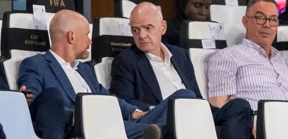 Three men seated in stadium VIP section