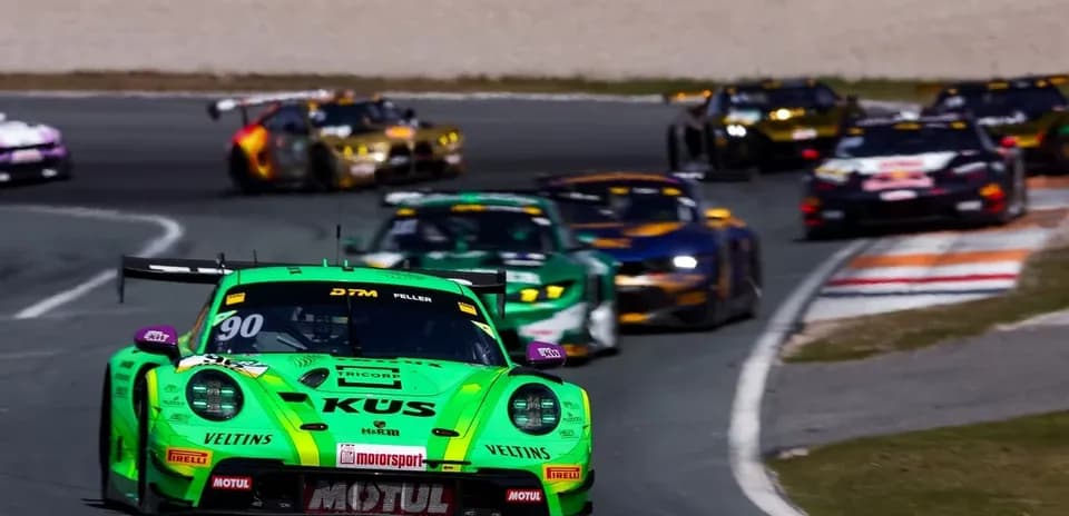Green racing car leading a pack on track
