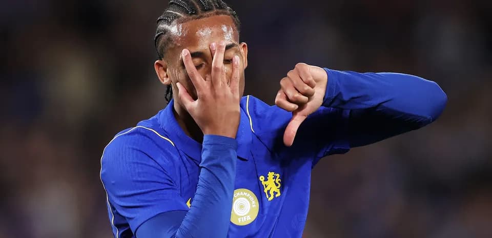 Futbolchi Chelsea formasida, qo'l bilan norozilik bildirmoqda