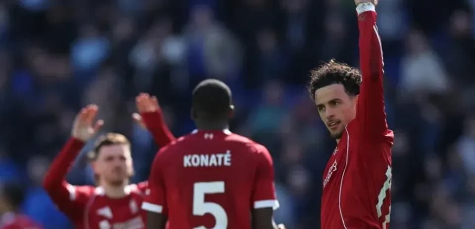 Ikkita futbolchi va Konate maydonda ko'tarilgan qo'l bilan
