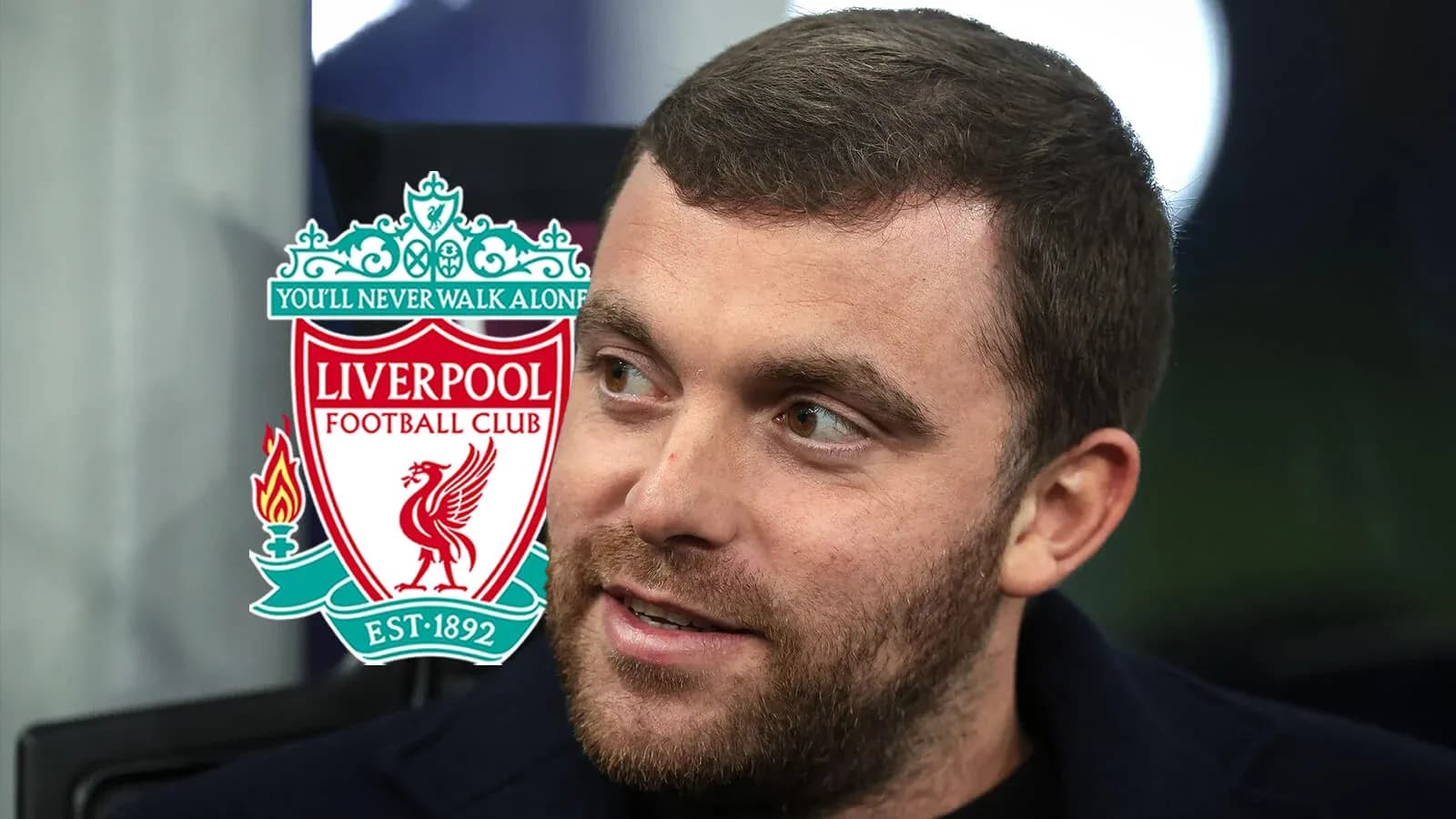 Man speaking with Liverpool FC logo in background