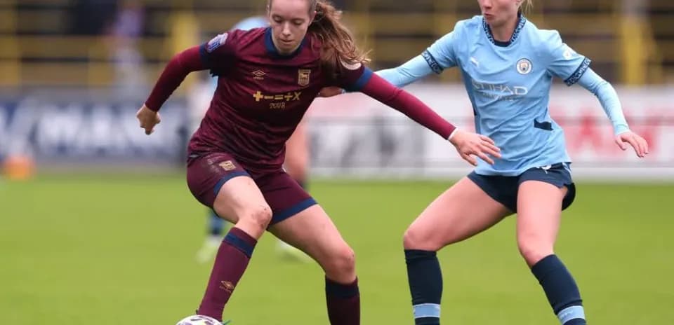 Two female players competing for the ball in match