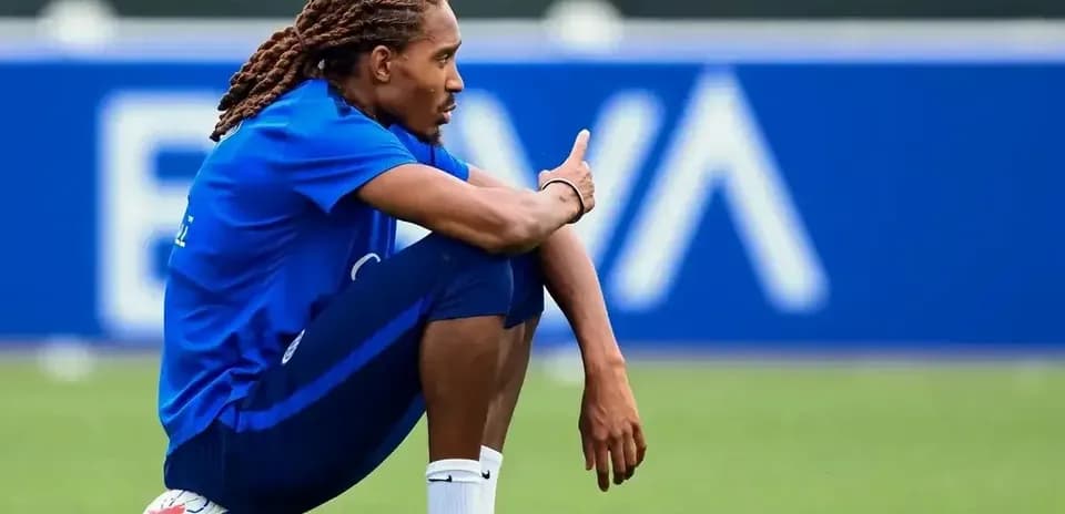 Futbolchi o'yin to'piga suyangan holda o'tirgan
