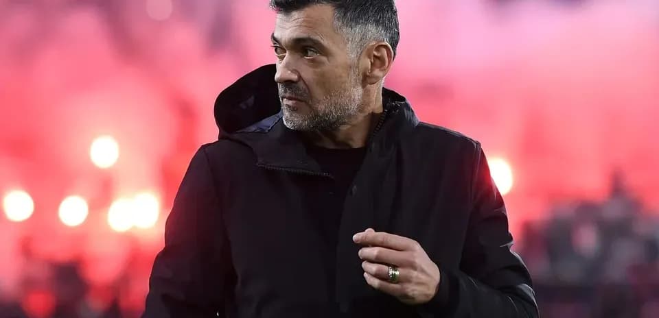 Men coach on sideline with smoke in background