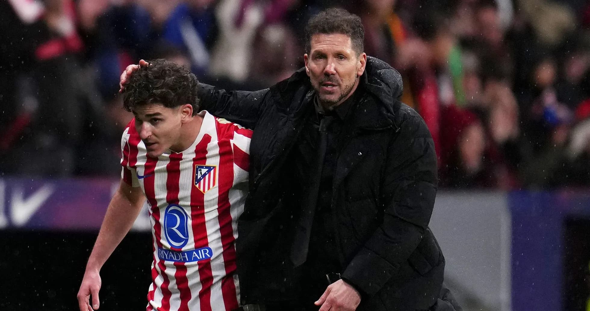 Atlético Madrid player assisted by coach during match