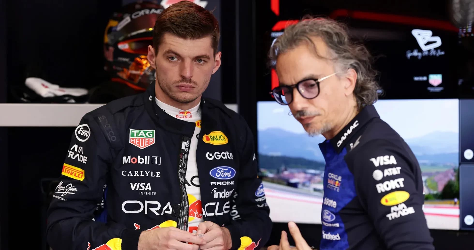 Max Verstappen and team member discussing in garage