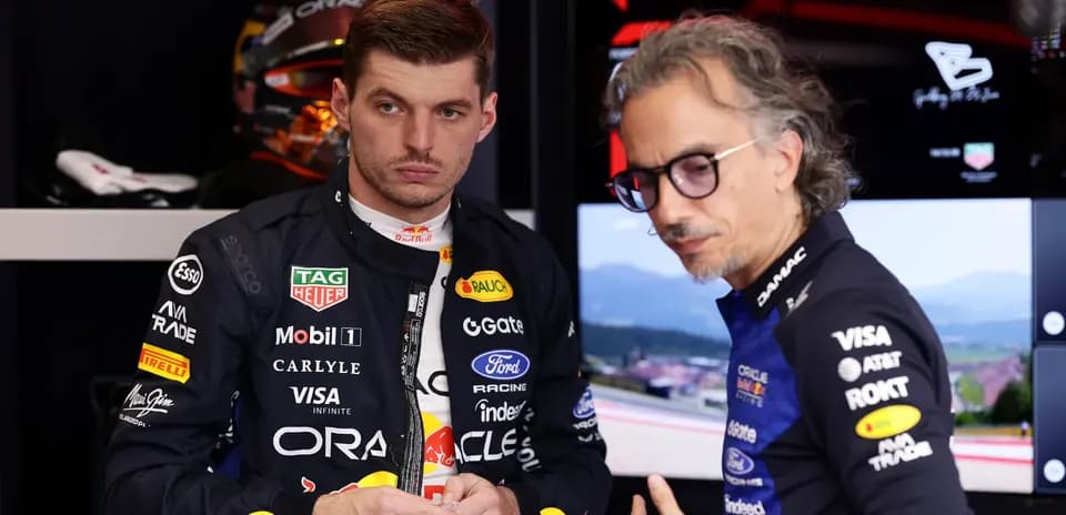 Max Verstappen and team member discussing in garage