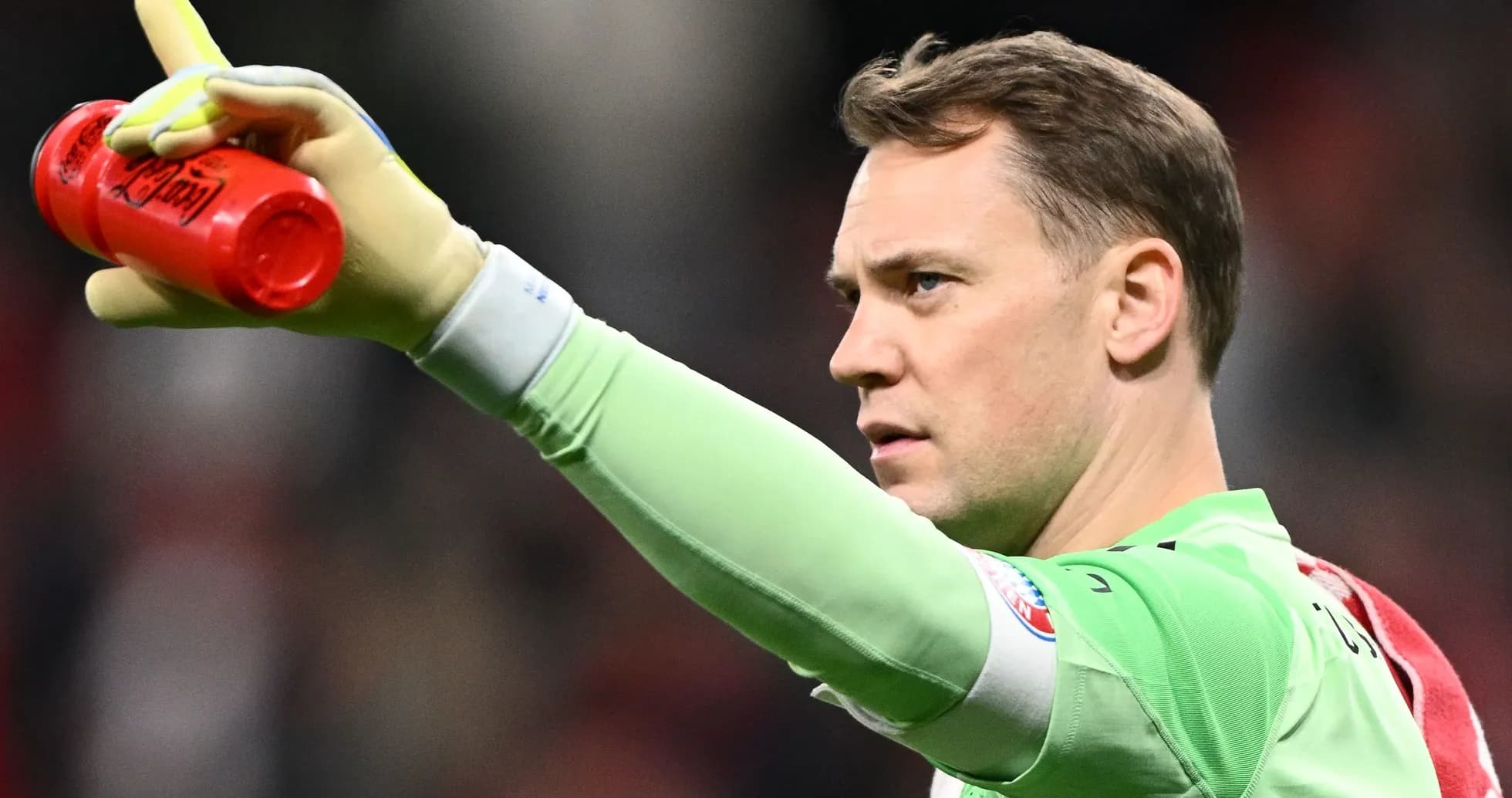 Goalkeeper holding water bottle and signaling during match