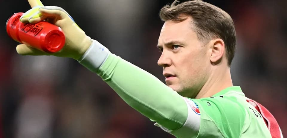 Goalkeeper holding water bottle and signaling during match