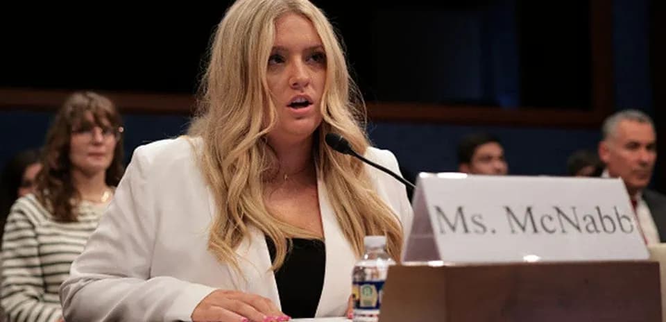 Woman testifying at congressional hearing with audience