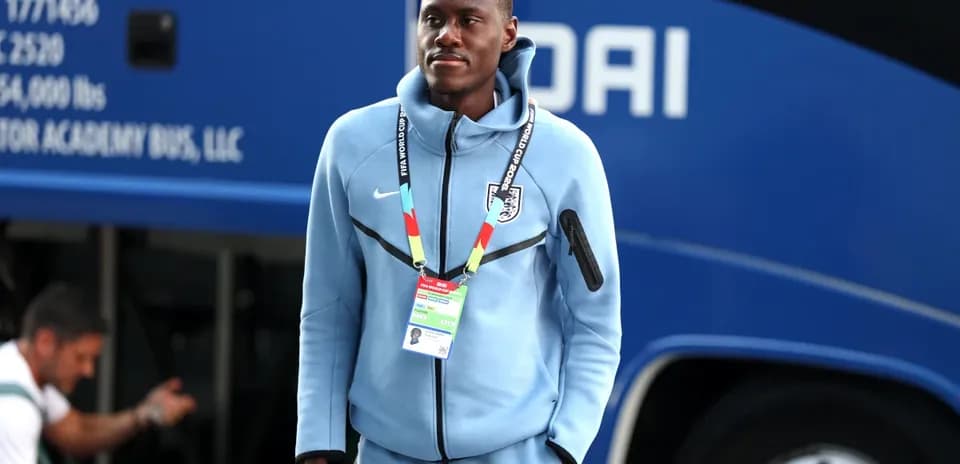Futbolchi jamoa avtobusi oldida turgan