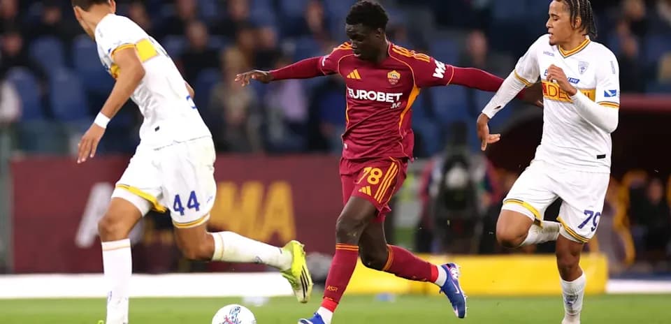 Roma player dribbling past two opponents during match