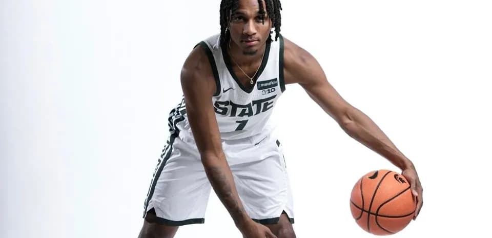 Basketball player posing with ball in uniform