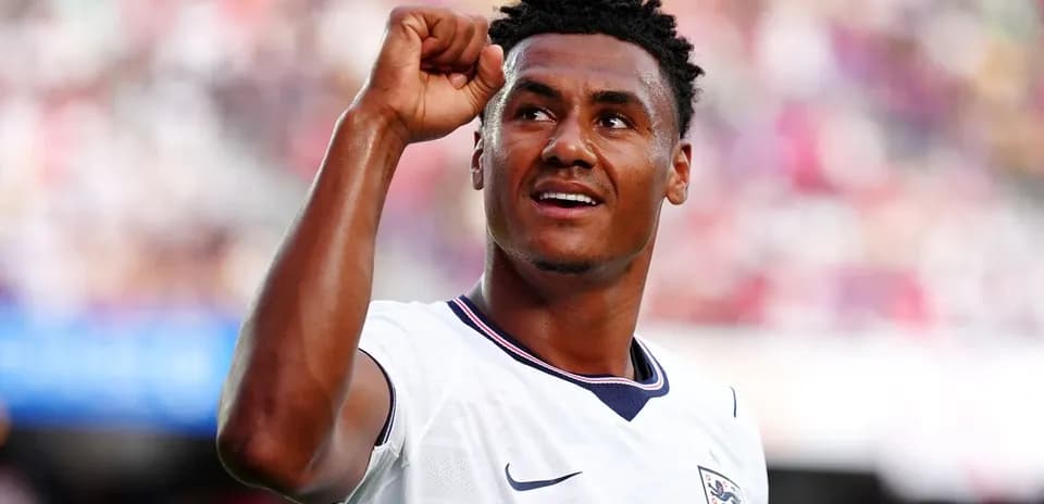 Futbolchi g'alaba bilan qo'lni ko'tarib turibdi