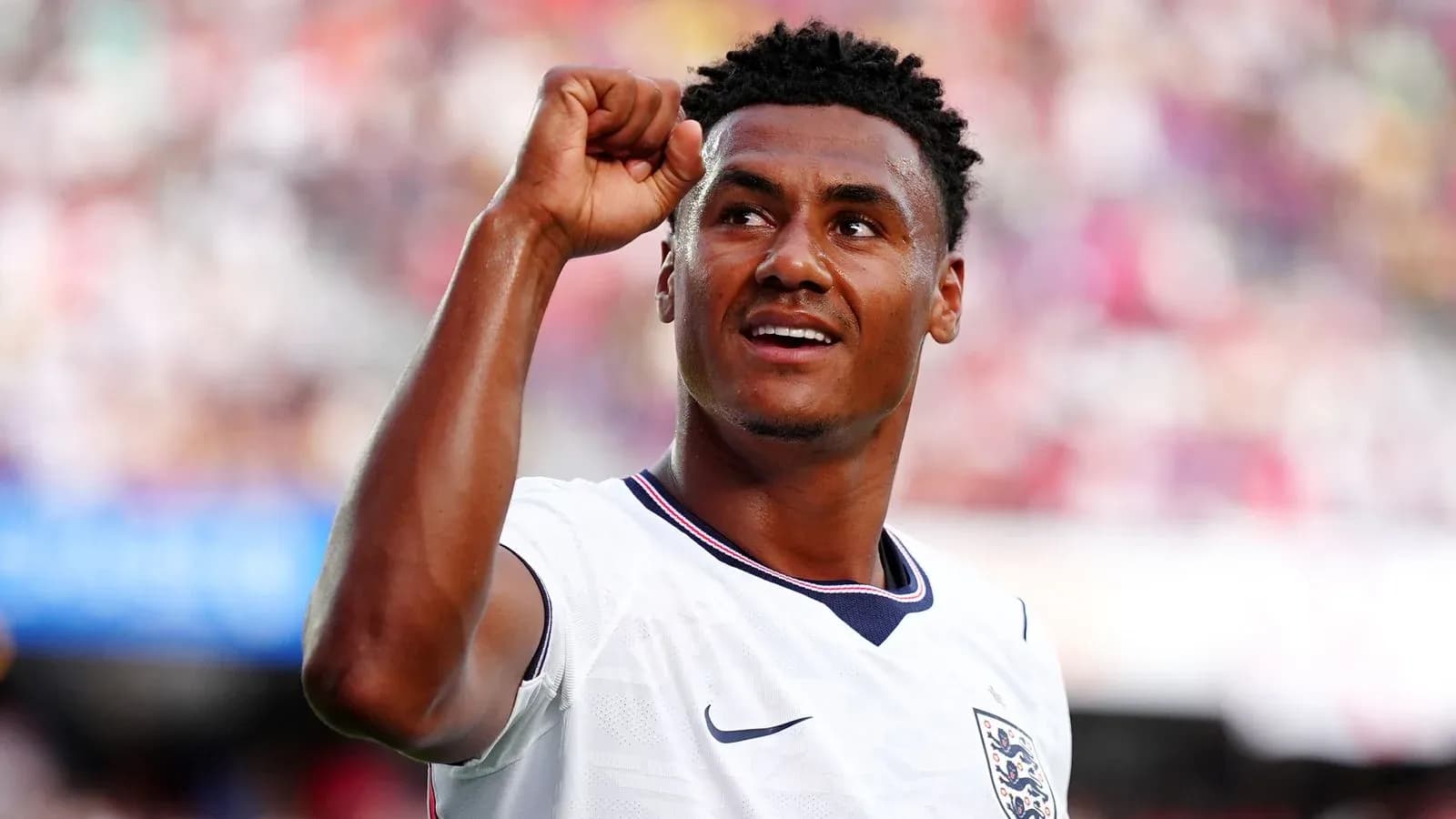 Futbolchi g'alaba bilan qo'lni ko'tarib turibdi