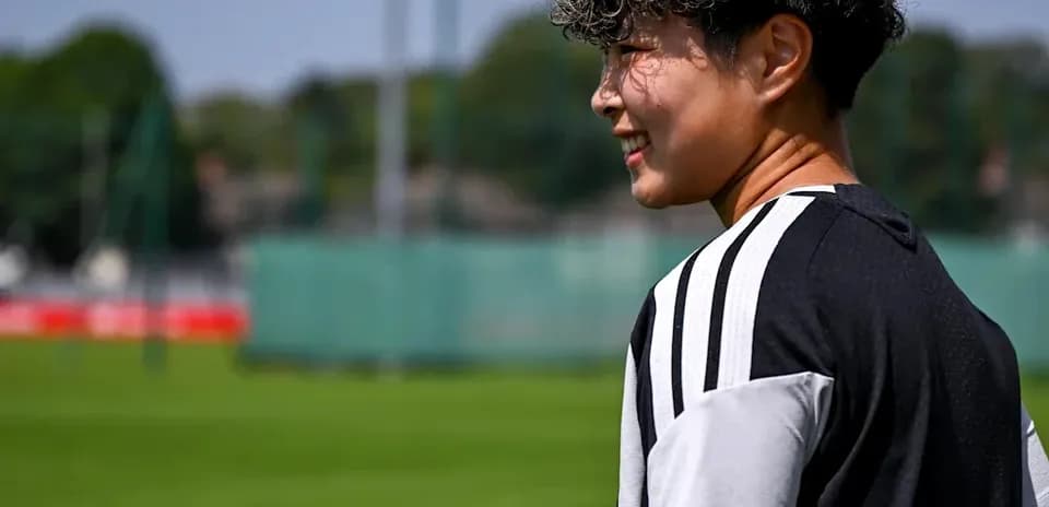 Futbolchi mashg'ulot maydonida orqadan qarab turibdi