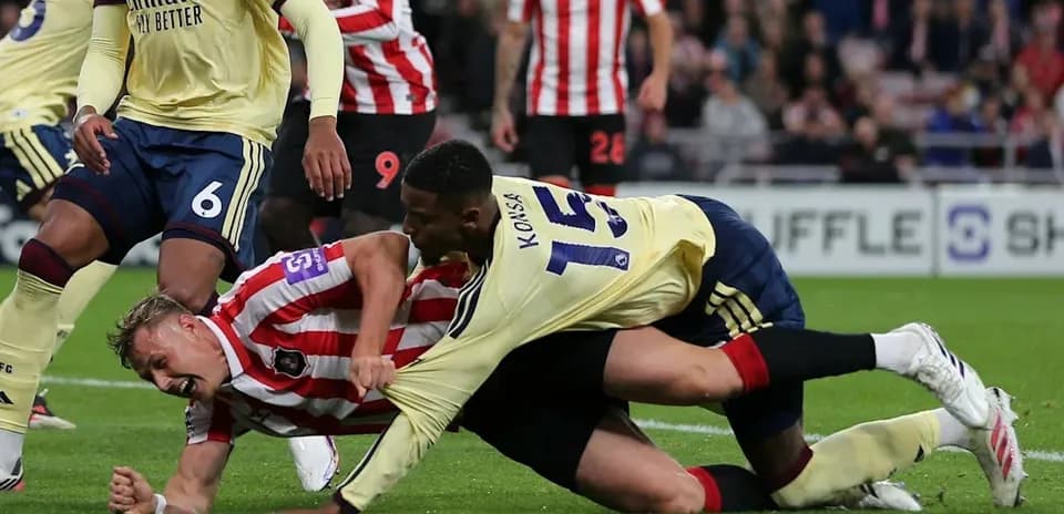 Two players battling for the ball on the ground