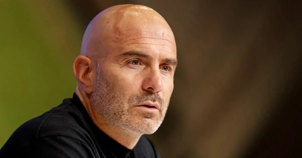 Bald man speaking at a press conference
