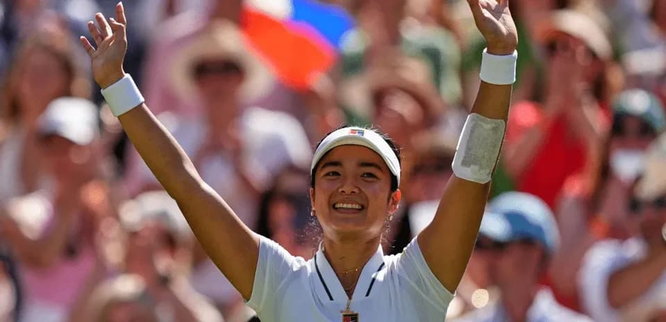 Tennis player celebrating in front of cheering crowd