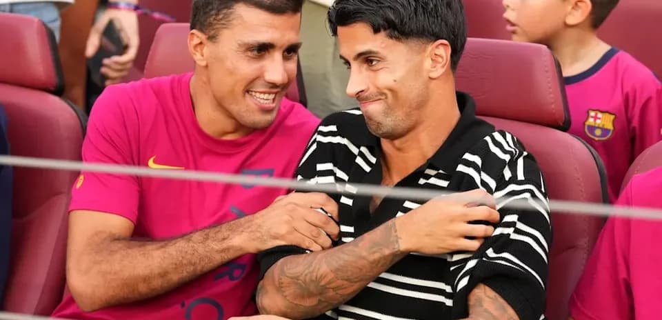 Ikkita futbolchi stulda o'tirib suhbatlashmoqda