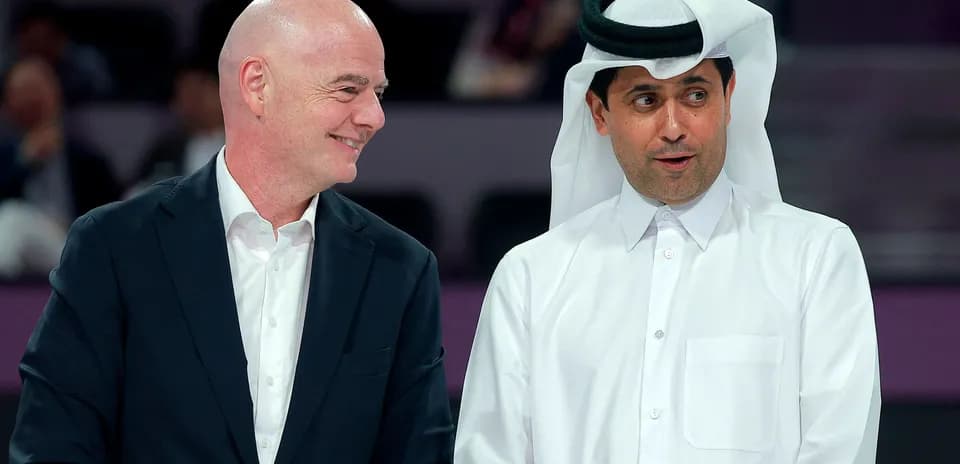 Two men conversing at an event in Qatar