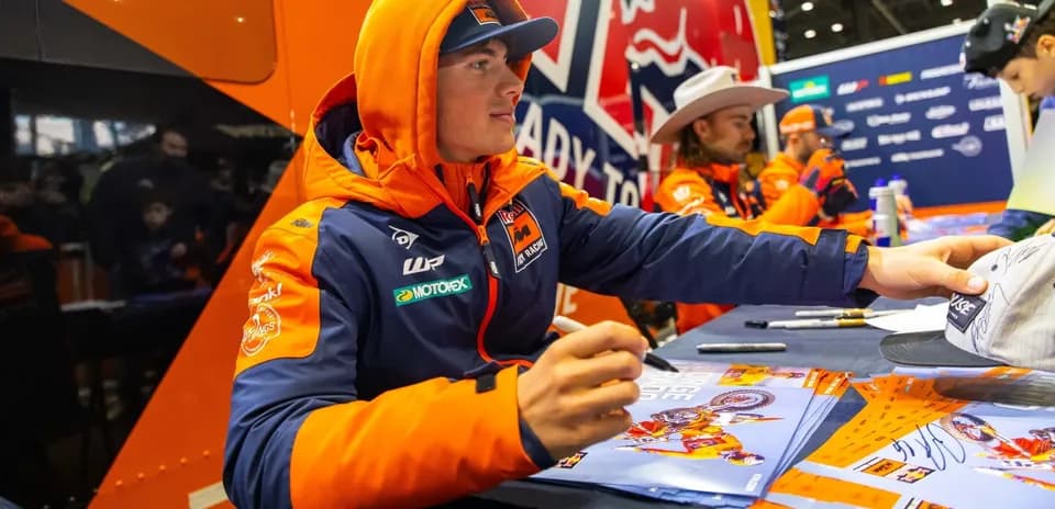 Rider signing autographs at promotional event