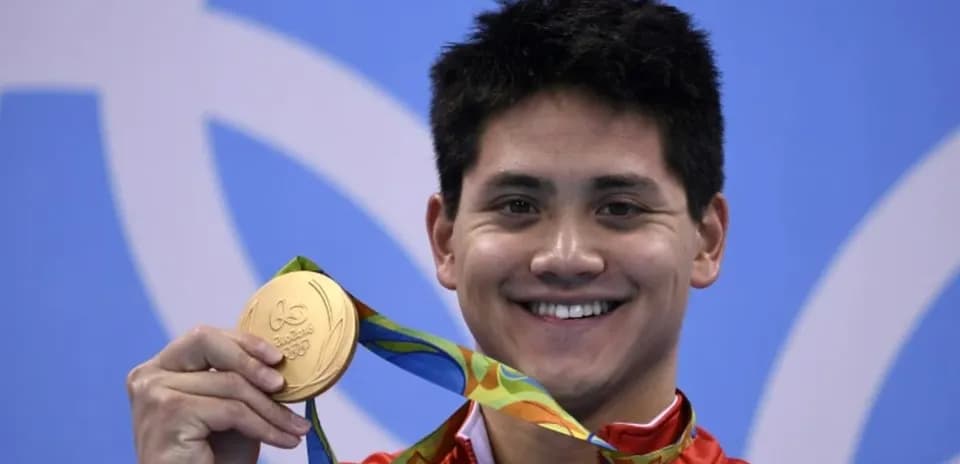 Sportchi oltin medalini ko'tarib turibdi