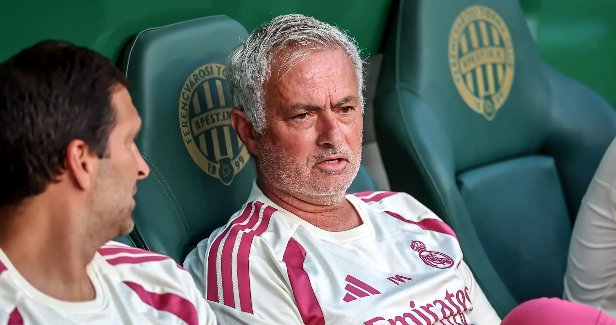 Mourinho sitting on bench with team staff