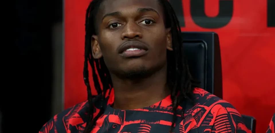 Futbolchi benchda o'tirgan, AC Milan formasida