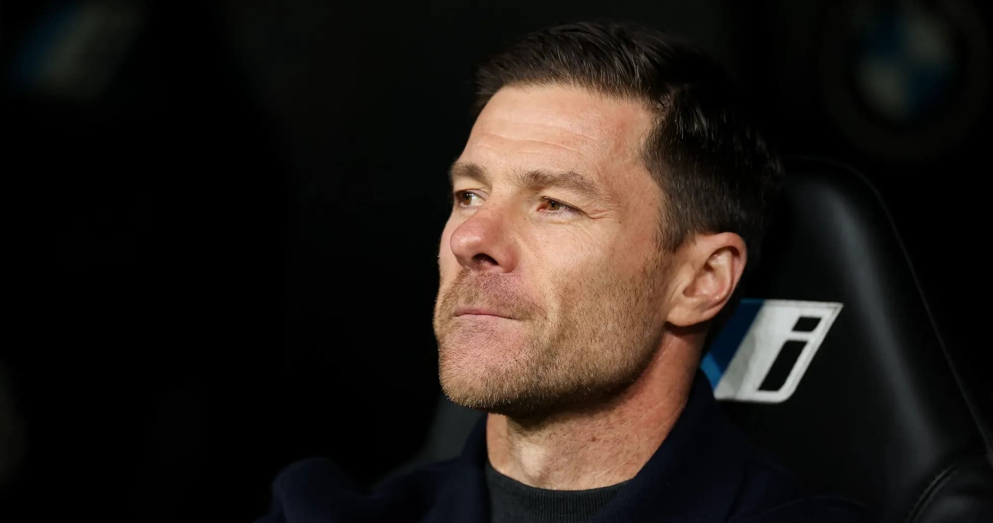 Football manager seated on the bench during match