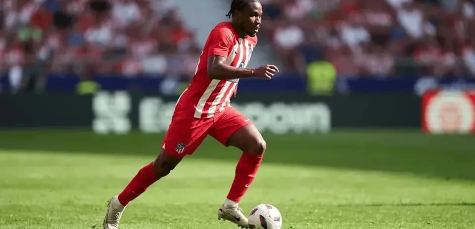 Futbolchi to'pni ushlab, maydon bo'ylab yugurmoqda
