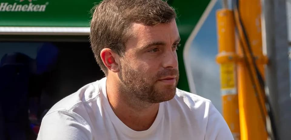 Man sitting near racing equipment in paddock