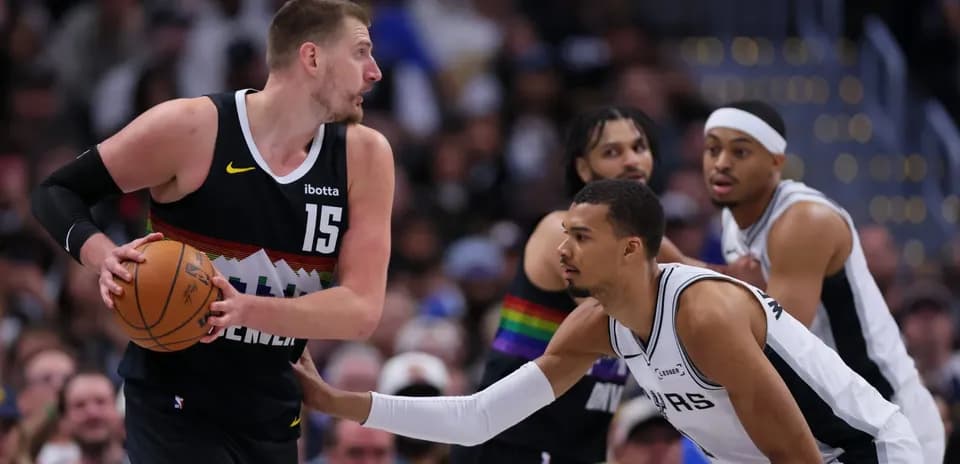 Nikola Jokić dribbling past defender during game