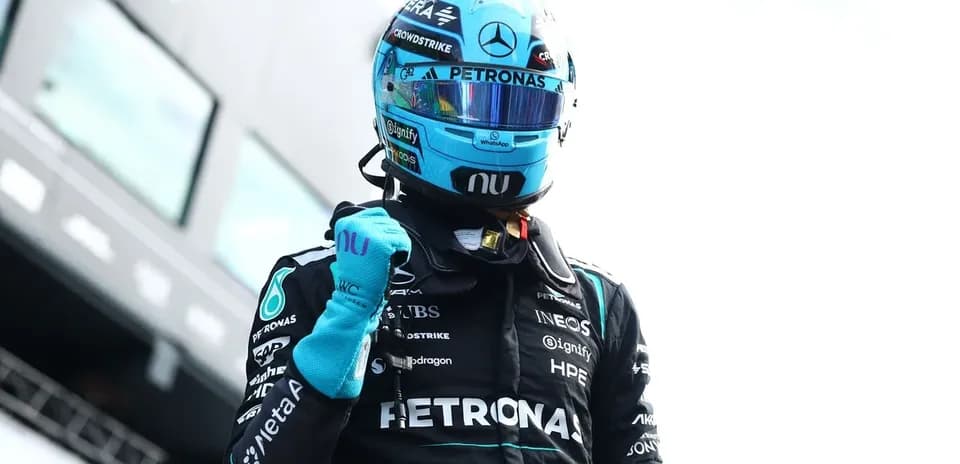F1 driver celebrating in racing suit after victory