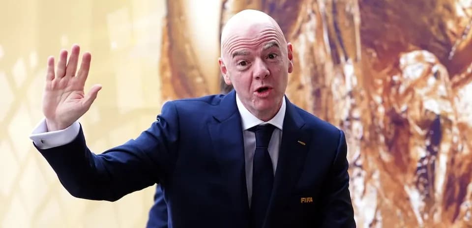 FIFA president speaking at event with trophy backdrop