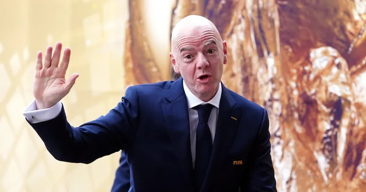 FIFA president speaking at event with trophy backdrop