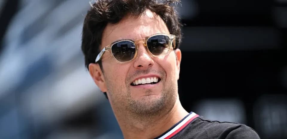 Shirtless man wearing sunglasses smiling outdoors