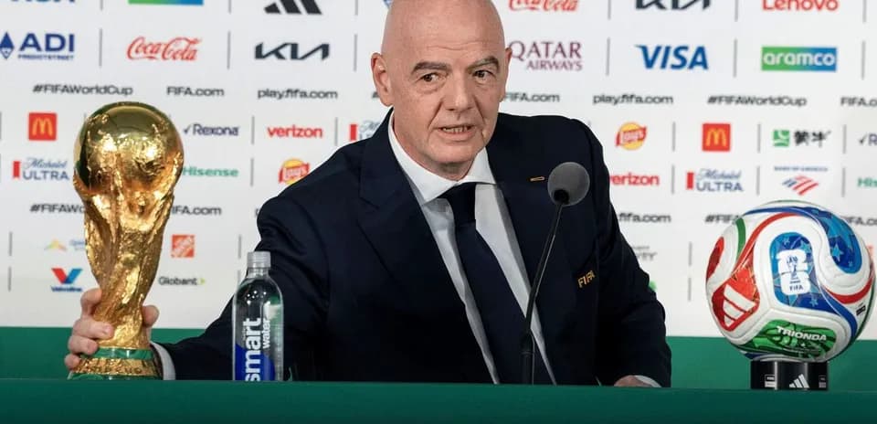 FIFA president holding World Cup trophy at podium