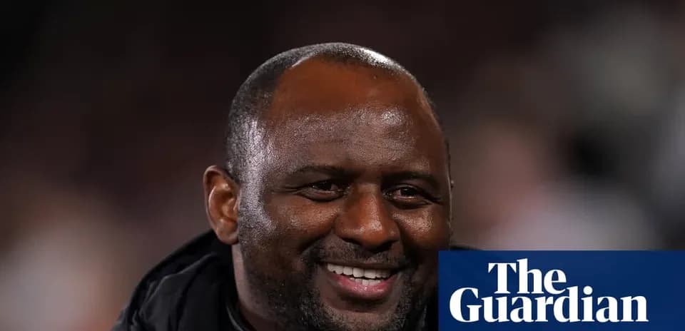 Men's football coach smiling during match