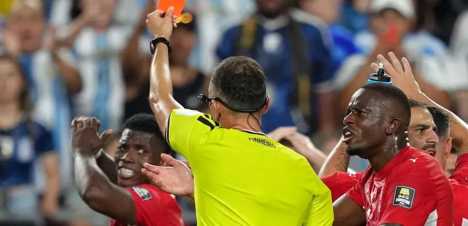 Referee shows red card to player during match