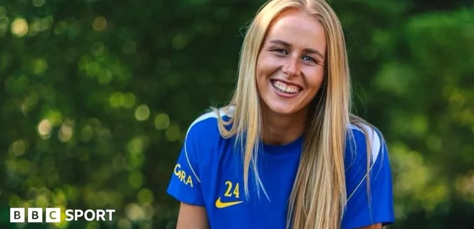 Futbolchi kulrang ko'ylakda tabassum qilmoqda