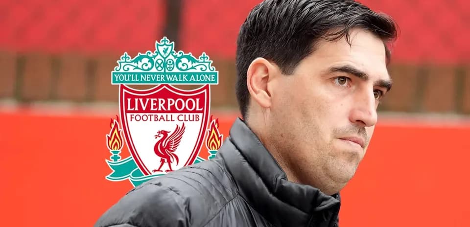Coach in front of Liverpool FC logo backdrop