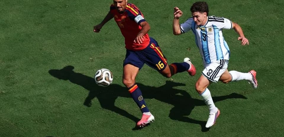 Ispaniya va Argentina futbolchilari to'p uchun kurashmoqda